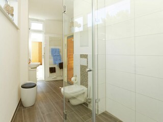 Badezimmer mit Infrarot-Wärmekabine ebenerdiger Dusche, Waschbecken und WC